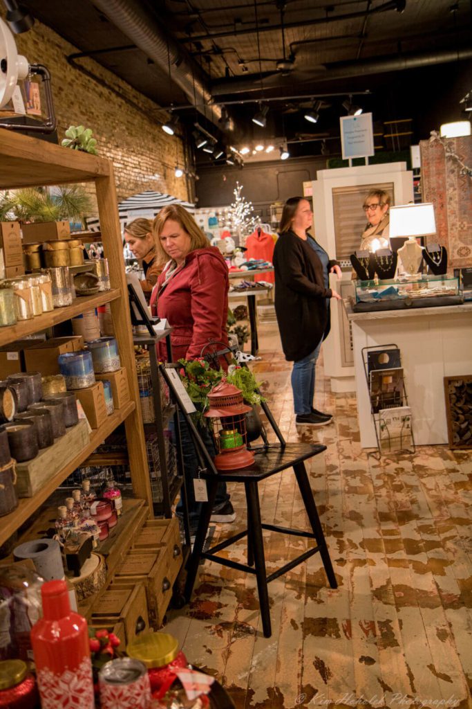 Several women browse items available in a downtown Janesville store, while the sales clerk looks on